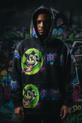 Men's oversized hoodie with all-over JuneBug cat character and paint splatter print in black green and purple colorway